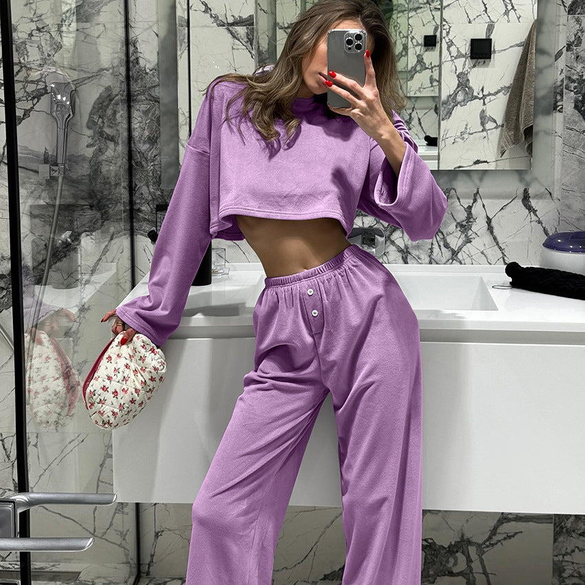 Person wearing a purple outfit taking a mirror selfie in a bathroom.